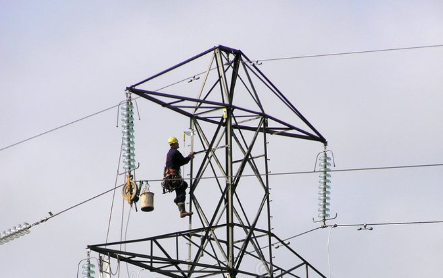 Line-worker on pylon with equipment hoist
